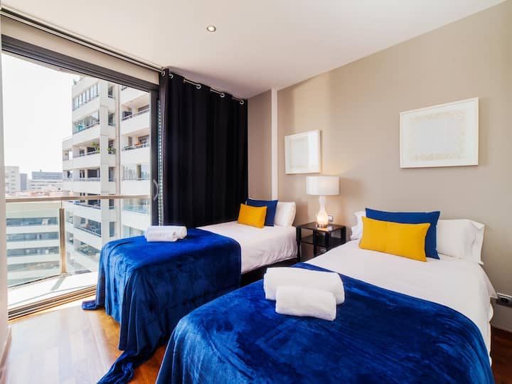 Dormitorio 3: este cómodo dormitorio cuenta con dos camas individuales, un armario y acceso directo al balcón. Sus ventanales del suelo al techo llenan la habitación de luz y ofrecen las mismas vistas impresionantes que el resto del apartamento.