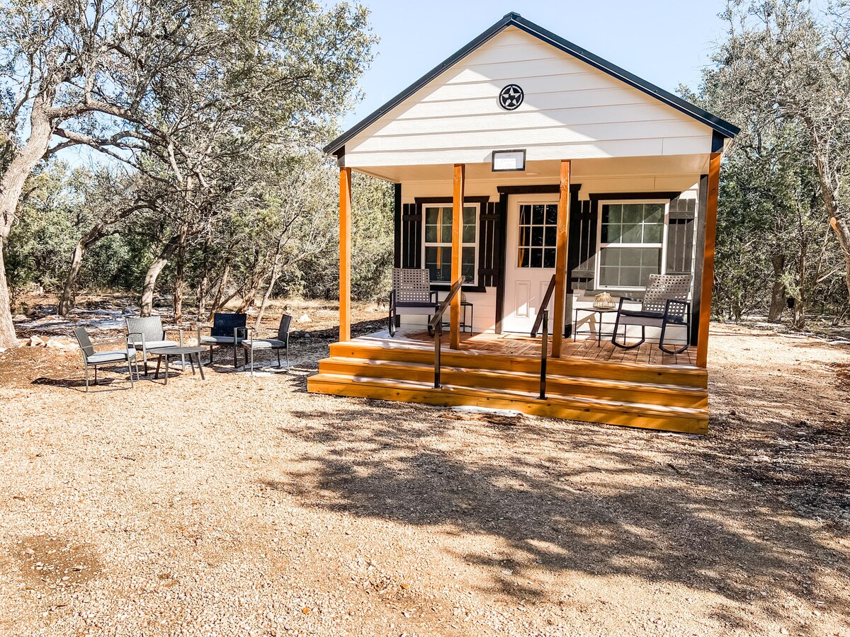Bunk cabin exterior with seating areas nestled in the trees