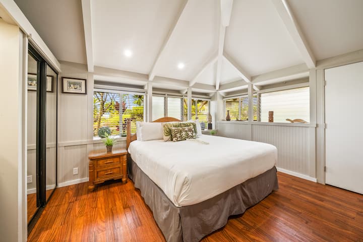 Acogedor dormitorio con cama tamaño king y grandes ventanales para la luz natural.