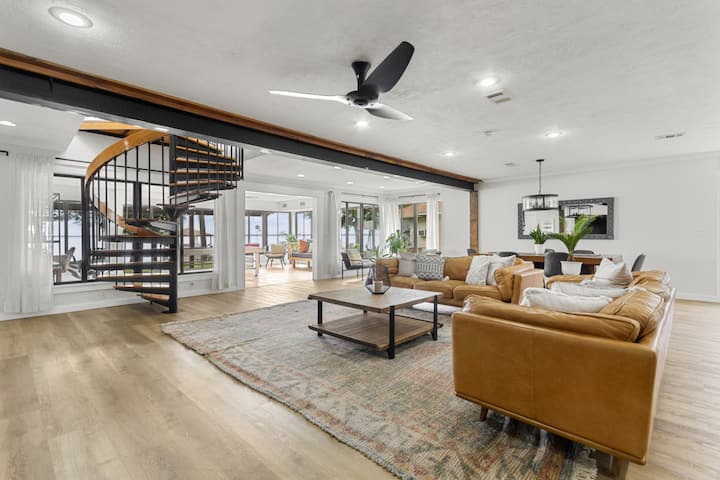 Spacious living room with dining area, spiral staircase, comfortable leather couches and a Smart TV with all your favorite apps.