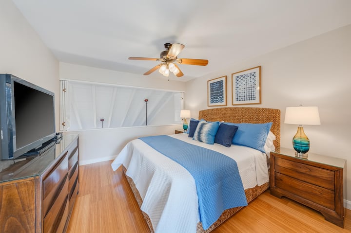Comfortable king bedroom with ceiling fan, flat-screen TV, and charming island-style details