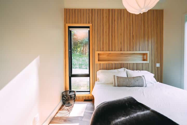 Bedroom 1.  Custom wood slat wall. Black out roller shades. 