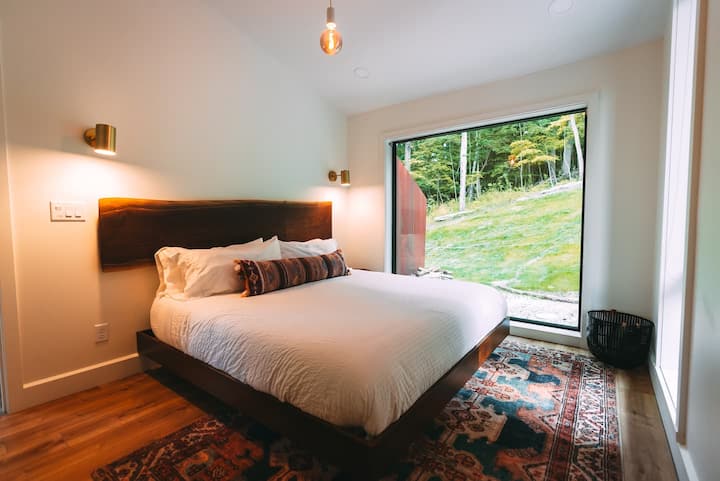 Bedroom 3.  custom black walnut headboard, 80 x 80 window with forest views. Black out roller shades. 
