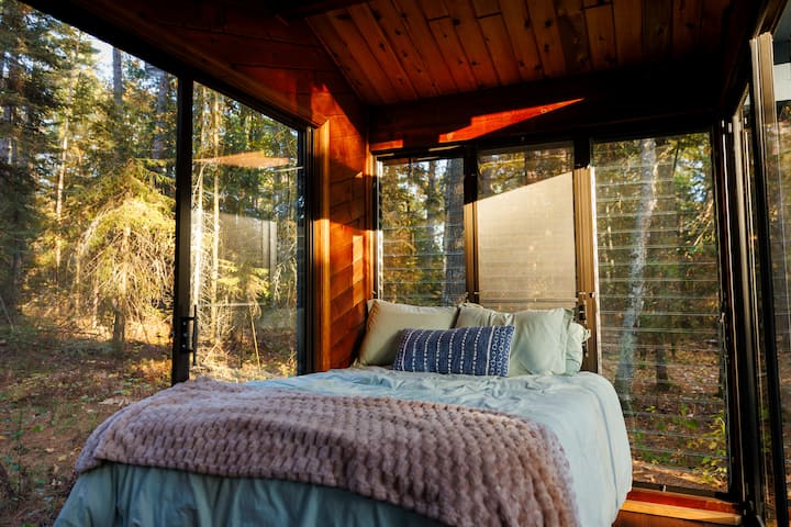 Spend the night or just the afternoon in the Secret Glass House | Open May-September | Check it out in winter! | Windows on 3-1/2 sides | Electricity, no heat | One double bed | Wicker chairs & table