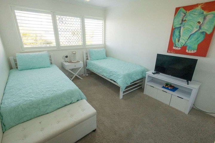 Tercer dormitorio luminoso con opciones flexibles para dormir. 
Dos camas individuales, televisor inteligente, ventilador de techo, cofre de juguetes y gran armario corredizo con espejo.