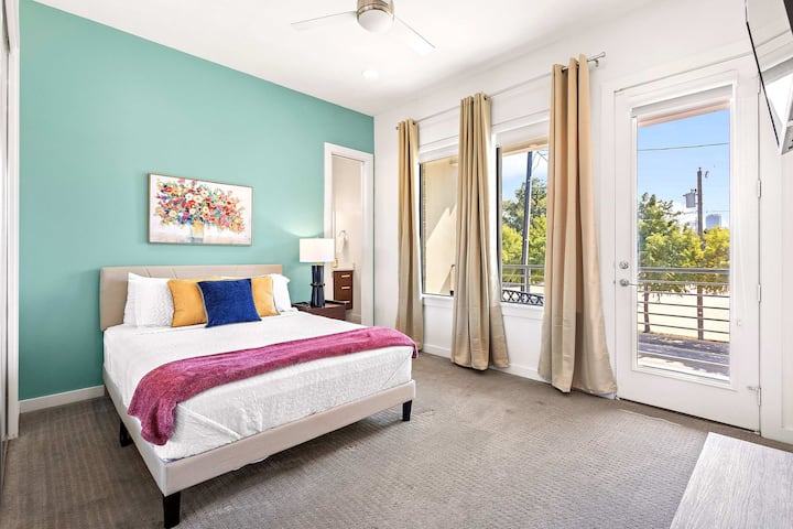Bright bedroom with soft green accents, cozy linens, and private balcony access for morning relaxation.