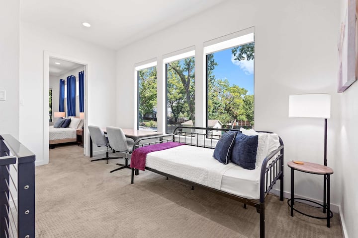 (Open Loft Area - Not a private Bedroom) 

Bright and cozy nook featuring a single daybed, large windows with lush views, and a compact workspace perfect for reading or remote work. 