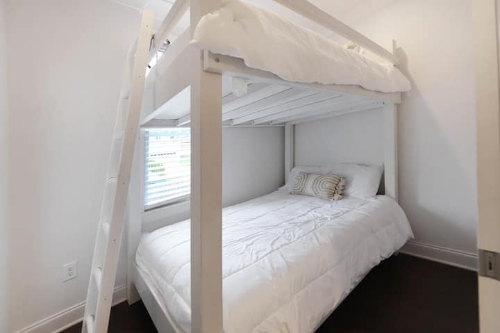 Სრული ზომის ორსართულიანი საწოლები აივანზე გასასვლელით, რომელიც სამზარეულოს მიმდებარედ, ძირითად დონეზე მდებარეობს.