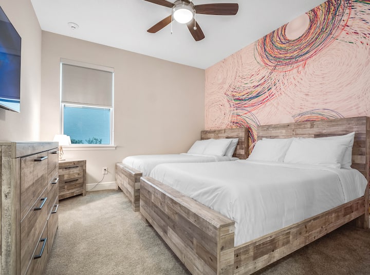 - Gastenkamer met twee queensize bedden en kleurrijke accentmuurkunst  
- Ruime indeling, perfect voor gezinnen die samen reizen  
- Smart-tv en comfortabele opstelling ideaal voor groepsverblijven