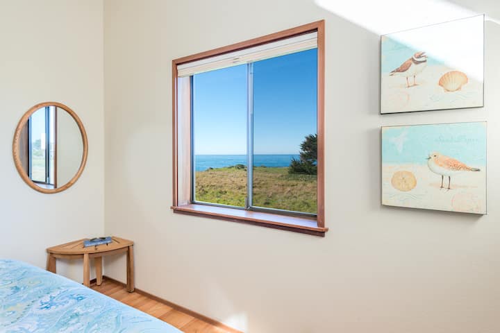 קסם החוף עם עידון שליו: התעוררו לנופי האוקיינוס ממוסגרים על ידי עיצוב חוף רך בחדר השינה המואר הזה, שבו הפשטות פוגשת את האלגנטיות של החיים על שפת הים.