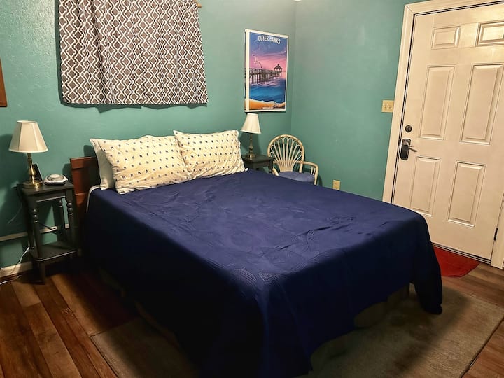 Stražnja spavaća soba s bračnim krevetom, komodom, aparatom za ozvučenje i paletom u boji koja smiruje i potiče opuštanje.  Nudi ormar, 32" Roku ready led TV i vlastiti vanjski ulaz.