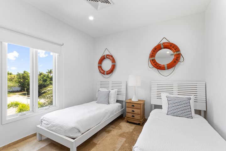 Krásna spálňa vily v Noord Aruba - Pohodlné 2 jednolôžka - Elegantne navrhnutá izba - Krásne maľované steny s výzdobou - Majestátne stolové lampy - Úhľadná a čistá posteľná bielizeň - Veľké okná s krásnym výhľadom