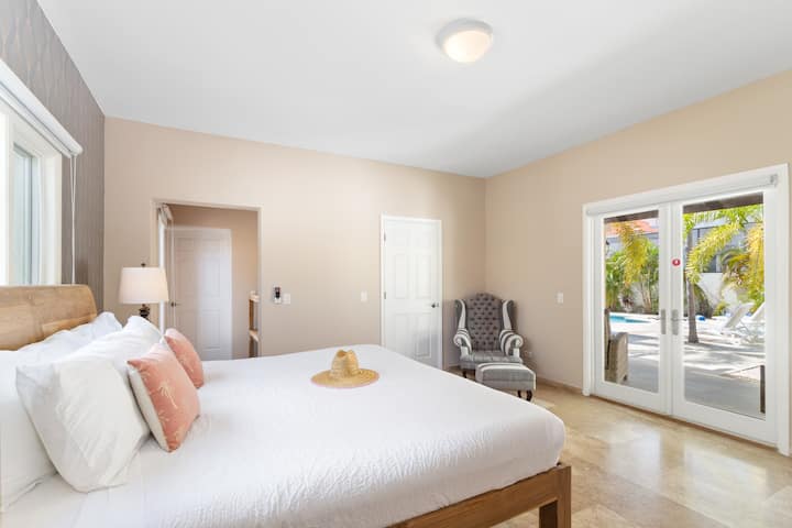 Nádherná spálňa vily v Noord Aruba - Pohodlná manželská posteľ - Elegantne navrhnutá izba - Krásne maľované steny s výzdobou - Majestátne stolové lampy - Úhľadná a čistá posteľná bielizeň - Veľké okná s krásnym výhľadom - TV a Netflix k dispozícii