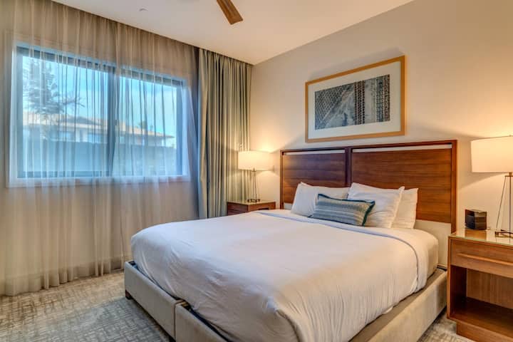 Chambre confortable avec très grand lit, draps moelleux et accents de bois chaleureux pour une nuit de sommeil réparatrice