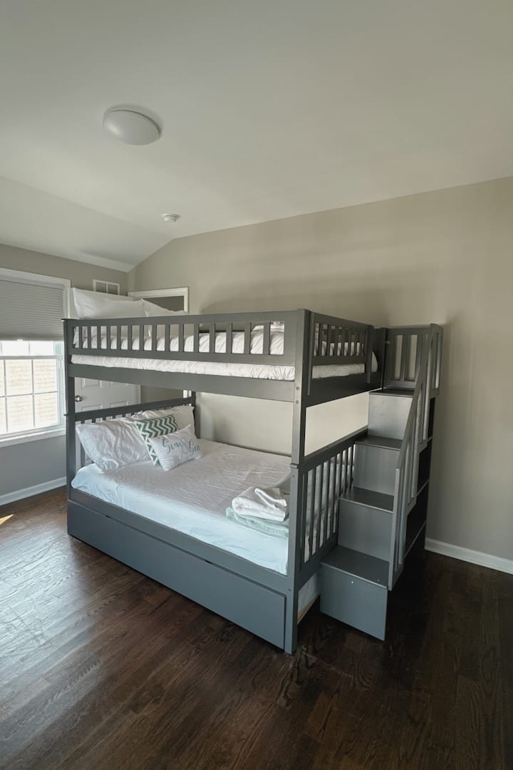 Esta habitación familiar es funcional y cómoda, con una litera resistente con una cama doble en la parte superior y una completa en la parte inferior, perfecta para familias o grupos. Los huéspedes apreciarán la escalera integrada con estantes de almacenamiento incorporados,