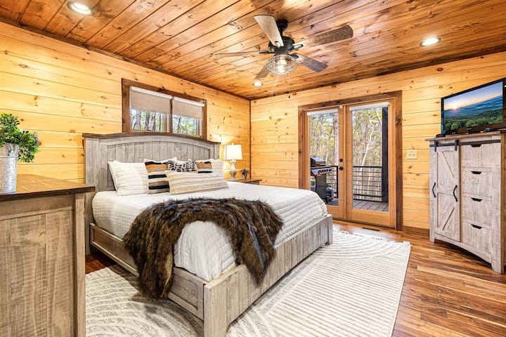 Main Level Master Bedroom features a comfortable king bed, dresser, closet, darkening shades, TV, fan