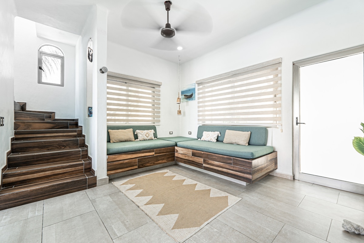 Sala con cama 2 sofás camas individuales y ventilador de techo