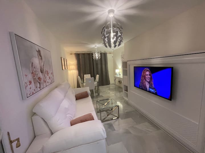 غرفة معيشة مع تلفزيون ذكي وقنوات باللغة الإنجليزية والإسبانية والفرنسية والألمانية وما إلى ذلك.