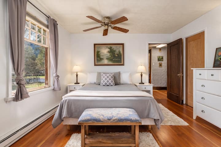 Залебдете во спокојна дремка во оваа мирна спална соба, каде што меката сива постелнина и топлите дрвени подови создаваат совршено место за одмор.