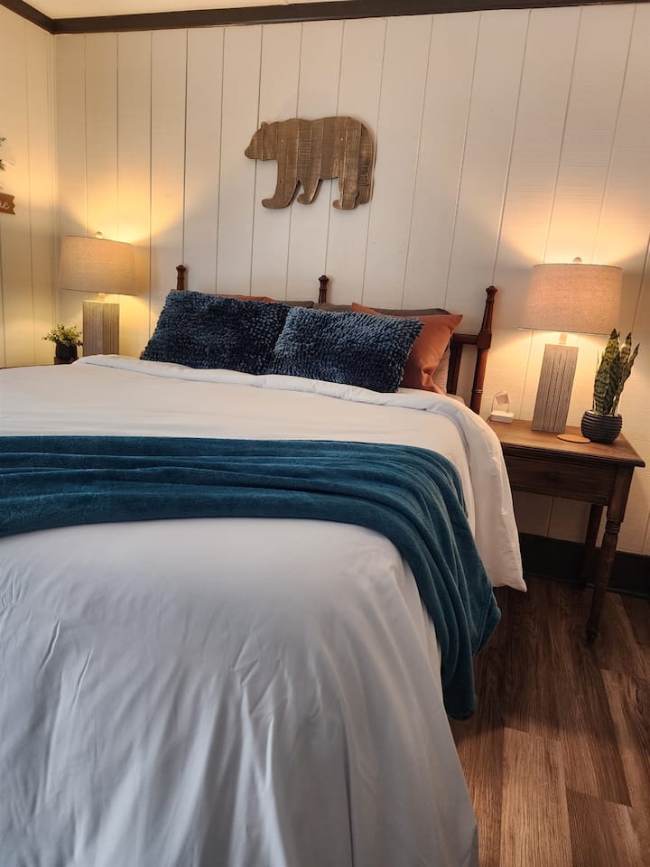 This cozy, queen bed master bedroom with a warm, bear themed decor is the perfect retreat after a long day full of activities.