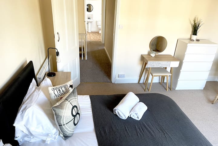 主卧室，配备加大双人床、衣柜和梳妆台。