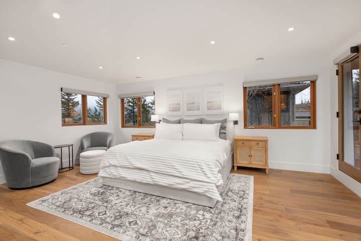 Suite principal de nivell superior amb llit «king size», televisor i accés al pati del terrat