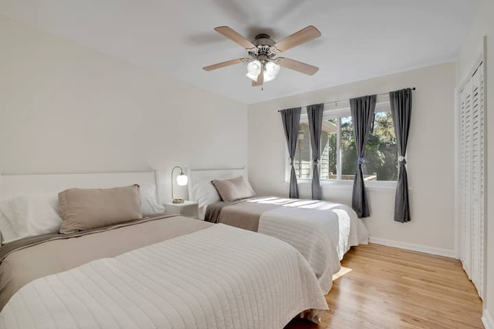 Dormitorio de invitados con 2 camas de tamaño completo y vestidor que se encuentra dentro del armario.