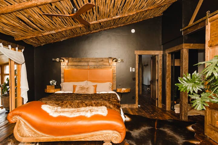 The east master bedroom has a king sized linen and goose down clad bed, a buffalo leather chaise, a balcony into the atrium, latilla ceiling, and emits the sexiest vibe.