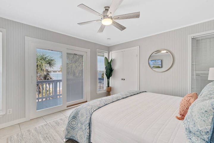 KING BEDROOM with patio doors to lagoon deck, water views and palm trees