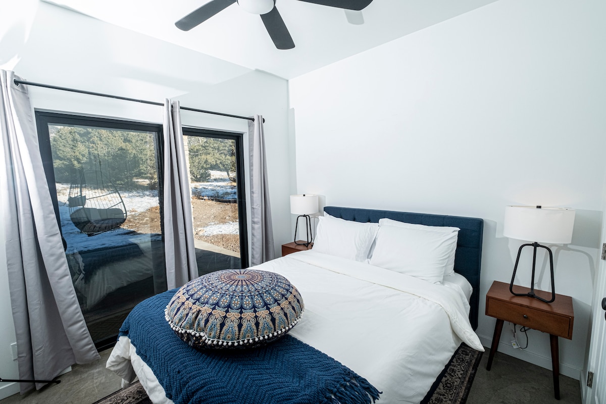 This charming bedroom boasts a comfortable queen bed and breathtaking mountain views through the sliding glass door. Step out onto the patio to enjoy the fresh air and sway in the swinging chair. The perfect spot to unwind after a day of adventure