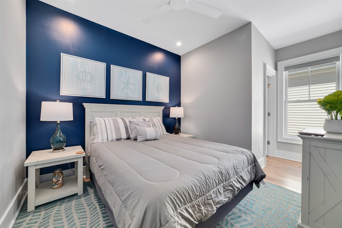 Queen room with dresser, ceiling fan and attached bath