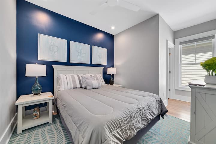 Queen room with dresser, ceiling fan and attached bath