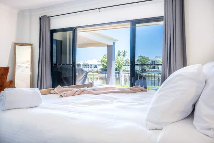 Chumba kikubwa cha kulala nyuma ya nyumba kilicho na kitanda aina ya king na mwonekano wa maji.