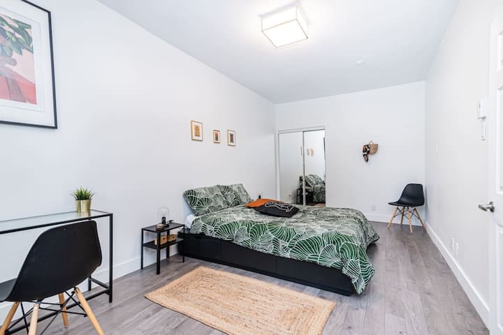 Chambre minimaliste chic avec un mélange harmonieux de tons de blanc, de noir et de bois pour une retraite élégante et apaisante.