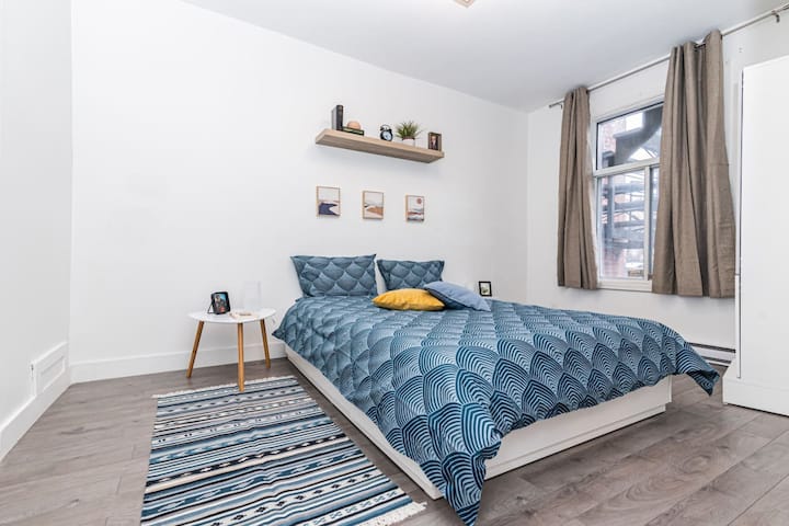 Une chambre blanche lumineuse avec un drap bleu apaisant, créant une atmosphère fraîche et relaxante.