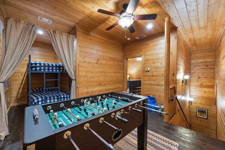 Sube las escaleras a la acogedora habitación de literas de la cabaña, donde las literas dobles ocultas ofrecen un refugio privado para los niños, y la mesa de futbolín promete horas de diversión para todas las edades.