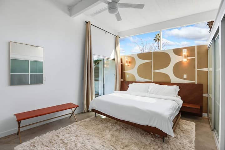 Spacious primary suite with king bed, ensuite bath, workspace, and direct hot tub access.