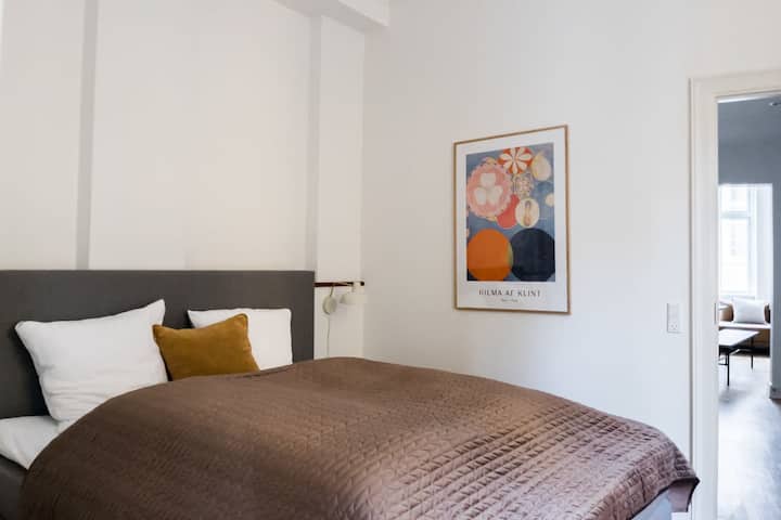 Дизајнот на спалната соба е елегантен и модерен, со фокус на удобност и релаксација. Комбинацијата од природна светлина, меки текстури и стилски декор создава простор кој е привлечен и мирен.