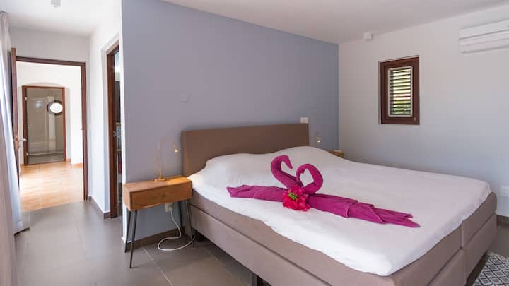 The master bedroom on the lower floor features a king sized bed, air conditioning, armoire, guest safe and ensuite bathroom.