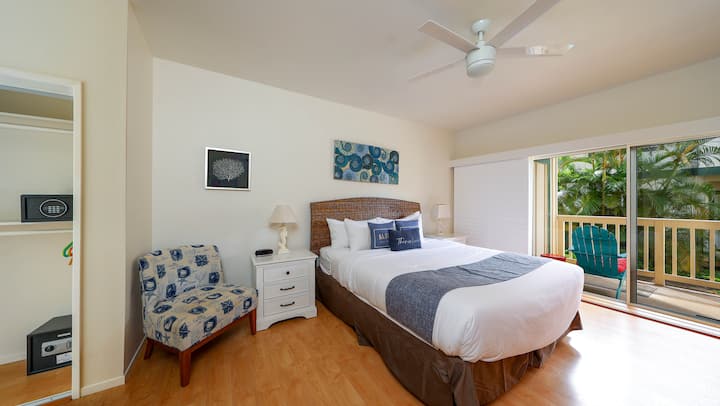 Dormitorio principal con cama tamaño queen, TV, aire acondicionado y ventiladores de techo