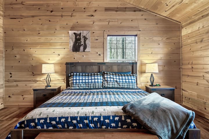 - Chumba cha kulala chenye ukuta wa mbao na mwanga laini kwa usiku wa kupumzika - Kitanda chenye starehe na matandiko ya mandhari ya mlima kamili kwa ajili ya kukaa kwenye nyumba ya mbao - Chumba cha amani kinachotoa asubuhi za kupumzika za Smoky Mountain