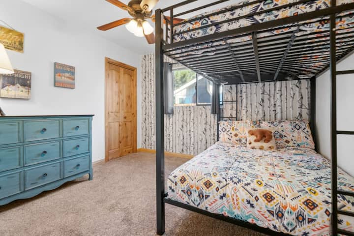 Забавна стая с двуетажни легла със здрави рамки и игриви спални принадлежности, идеална за деца или допълнителни гости.