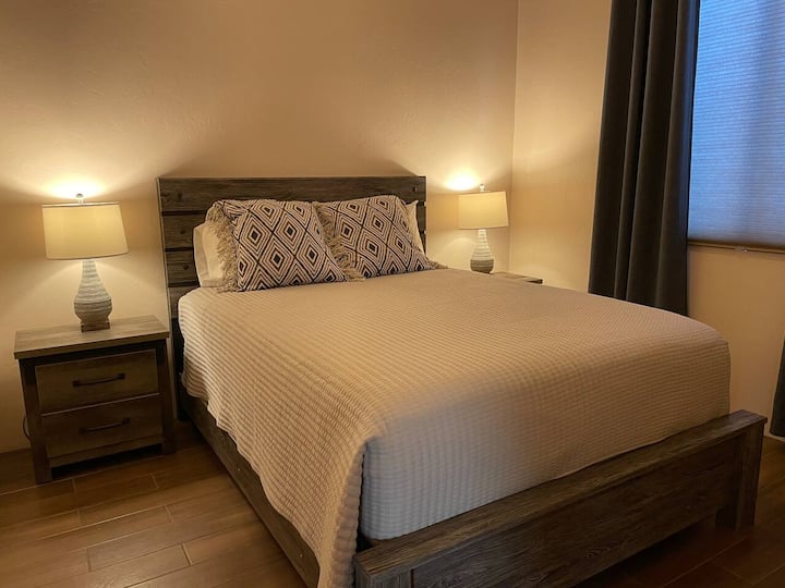 Kuwarto ng bisita na may queen bed at mga USB charging port sa mga nightstand. 