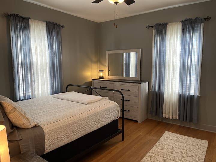 غرفة نوم بسرير بحجم كبير وخزانة ملابس وخزانة ملابس ومروحة سقف