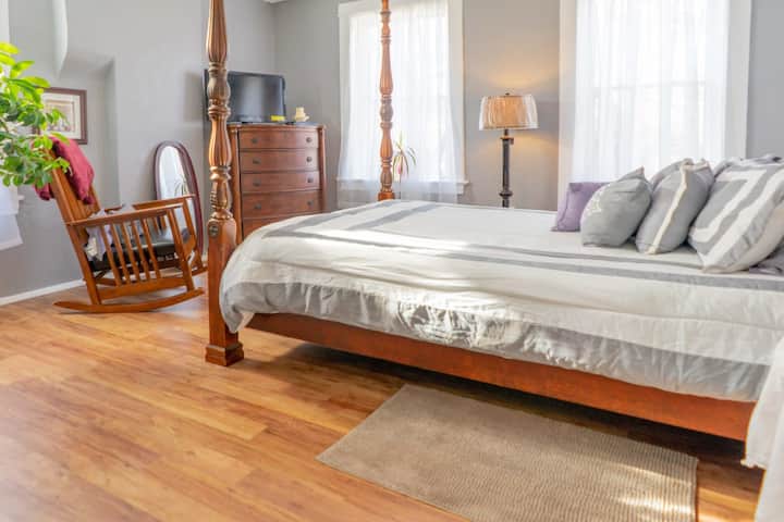 Cette chambre allie la grandeur d'un lit à baldaquin au confort intemporel d'une berceuse en bois classique. #ClassicComfort