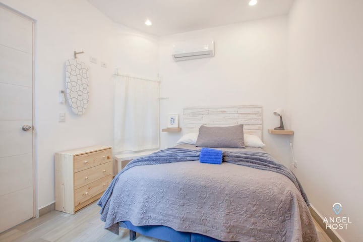 Dormitorio 2 con una lujosa cama tamaño queen, espacio para vestirse y aire acondicionado para mayor comodidad.