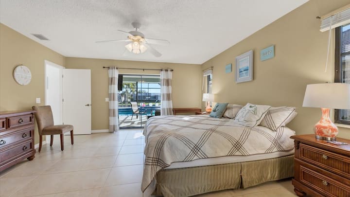 غرفة نوم رئيسية بسرير كبير مع مدخل إلى الفناء