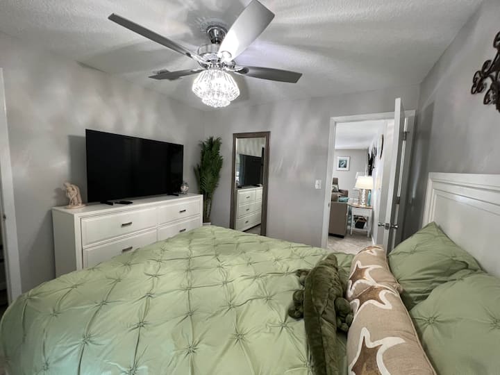 高尔夫卧室，配备风扇、UHD智能电视等