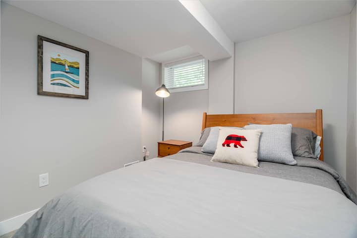 Bedroom with bear pillow and sailboat artwork near UWO