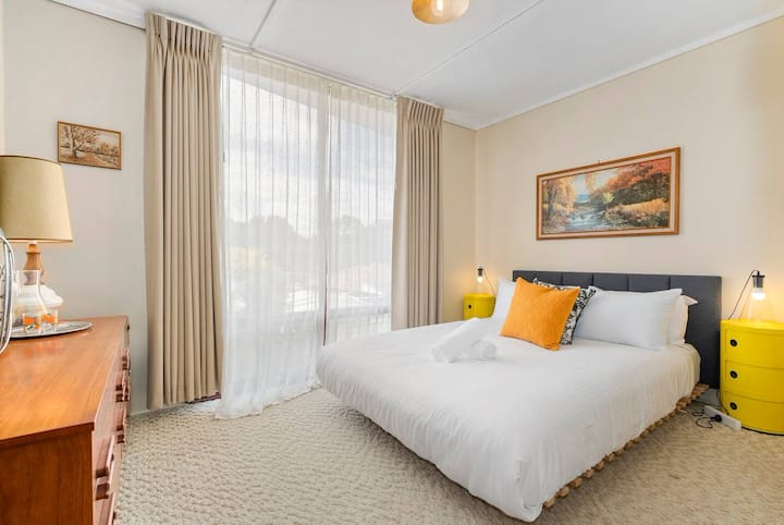 Მეორე საძინებელში არის საწოლი დიდი ზომის საწოლი და იატაკიდან ჭერამდე ფანჯრები, რომლებიც უბანს გადაჰყურებს.